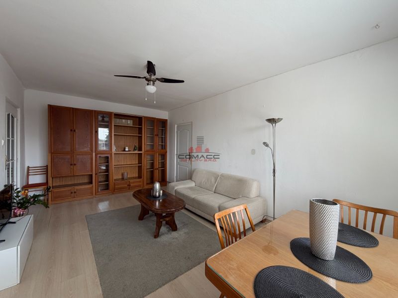 Wohnzimmer mit Holzboden, Sofa und Esstisch in einer 3-Zimmer-Wohnung.