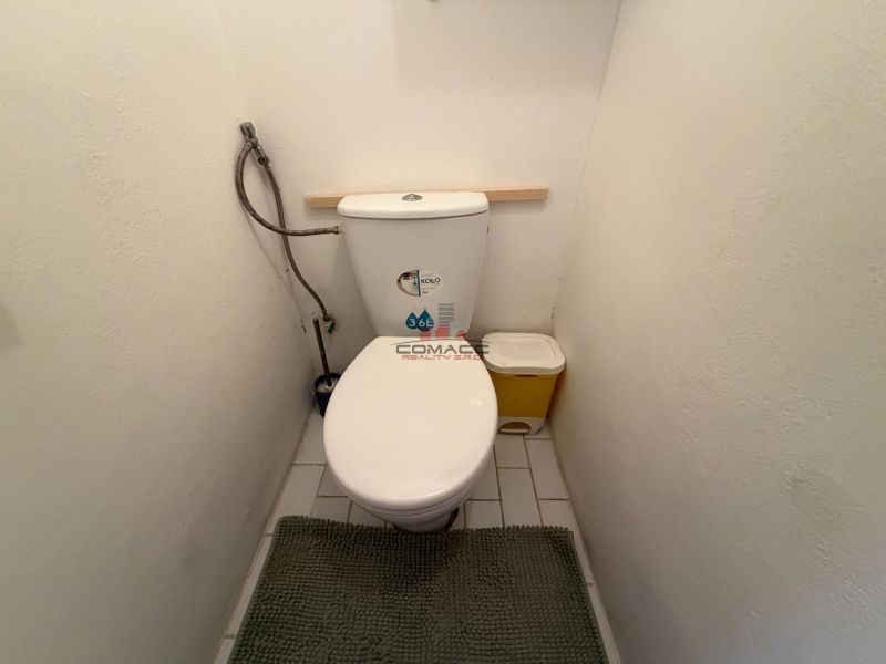 Toilette einer 3-Zimmer-Wohnung mit weißen Wänden und Fliesen.