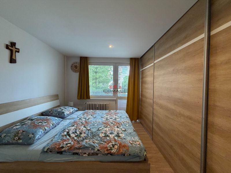 Schlafzimmer in einer 3-Zimmer-Wohnung mit Holzboden und Einbauschrank.