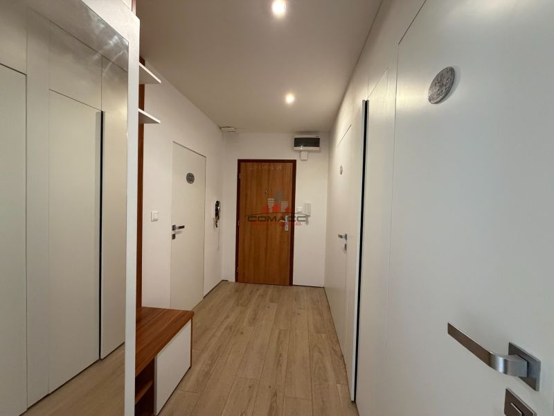 Der Flur in einer 3-Zimmer-Wohnung mit einem Boden in Holzoptik und weißen Wänden.