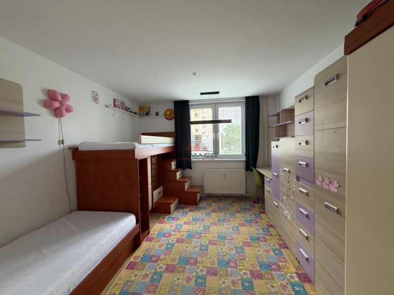 Kinderzimmer in einer 3-Zimmer-Wohnung mit einem bunten Teppich und einem Etagenbett.