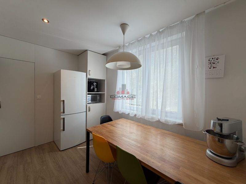 Eine Küche in hellen Farben mit einem Holzboden in einer 3-Zimmer-Wohnung.