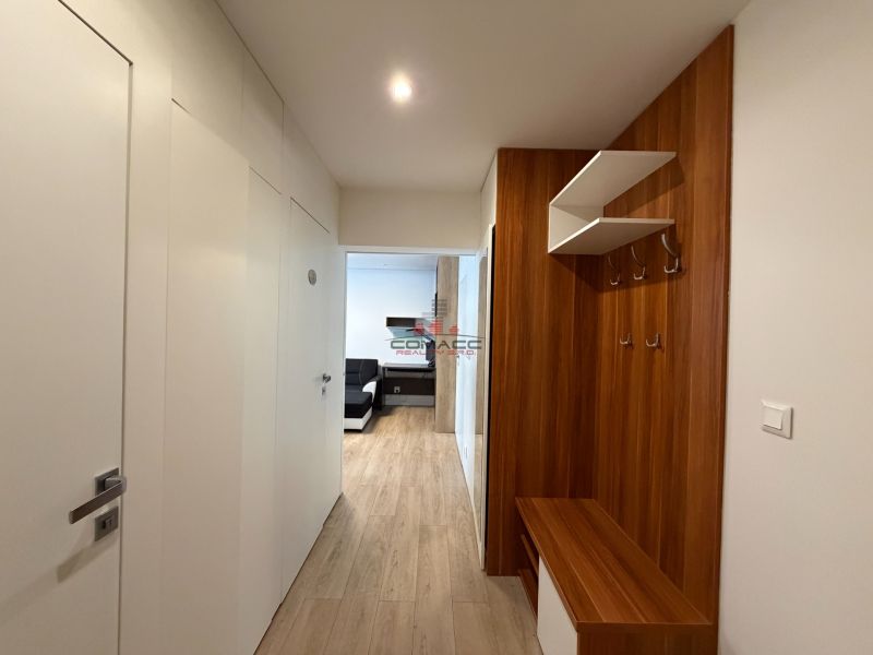 Flur mit Schrank und Holzboden in einer 3-Zimmer-Wohnung.