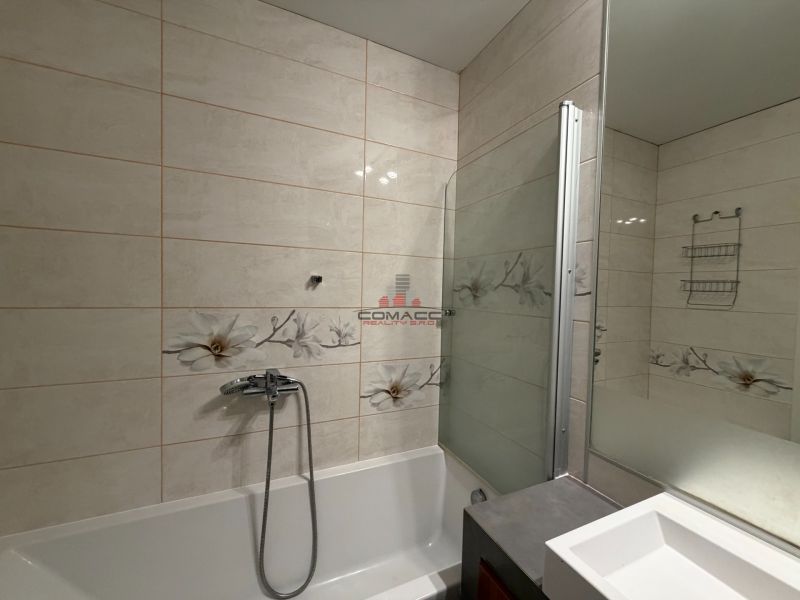 Badezimmer in einer 3-Zimmer-Wohnung mit Duschkabine und Blumenfliesen.