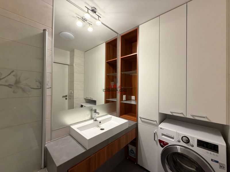 Badezimmer mit Waschbecken, Waschmaschine und Stauraum in einer 3-Zimmer-Wohnung.