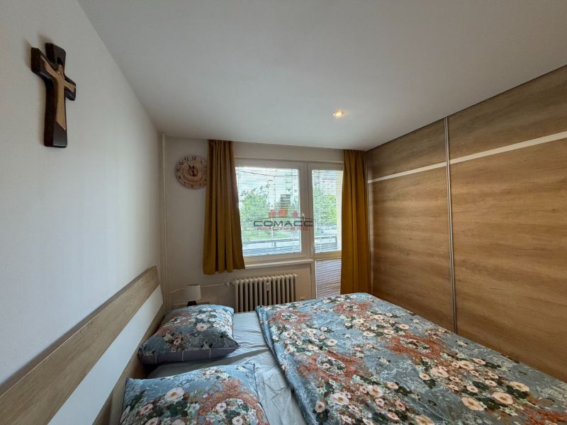 Schlafzimmer mit großem Kleiderschrank, Doppelbett und Fenster in einer 3-Zimmer-Wohnung.