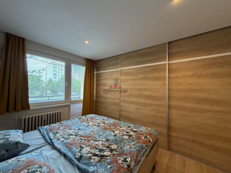 Schlafzimmer in einer 3-Zimmer-Wohnung mit Holzboden und Kleiderschrank.