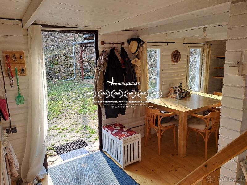 Ein Holztisch und Stühle in einer Hütte mit Blick auf den Garten.