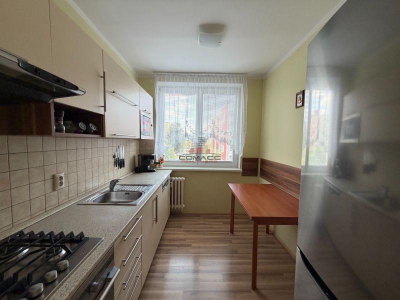 Küche in einer 3-Zimmer-Wohnung mit einem Holzboden und einer Küchenzeile.