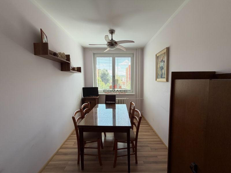 Esszimmer mit Holztisch, Stühlen und Boden mit Holzdekor in einer 3-Zimmer-Wohnung.