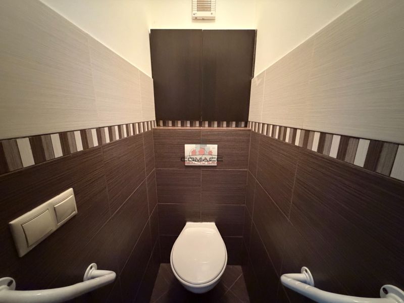 Toilette mit gemusterten Fliesen in einer 3-Zimmer-Wohnung.