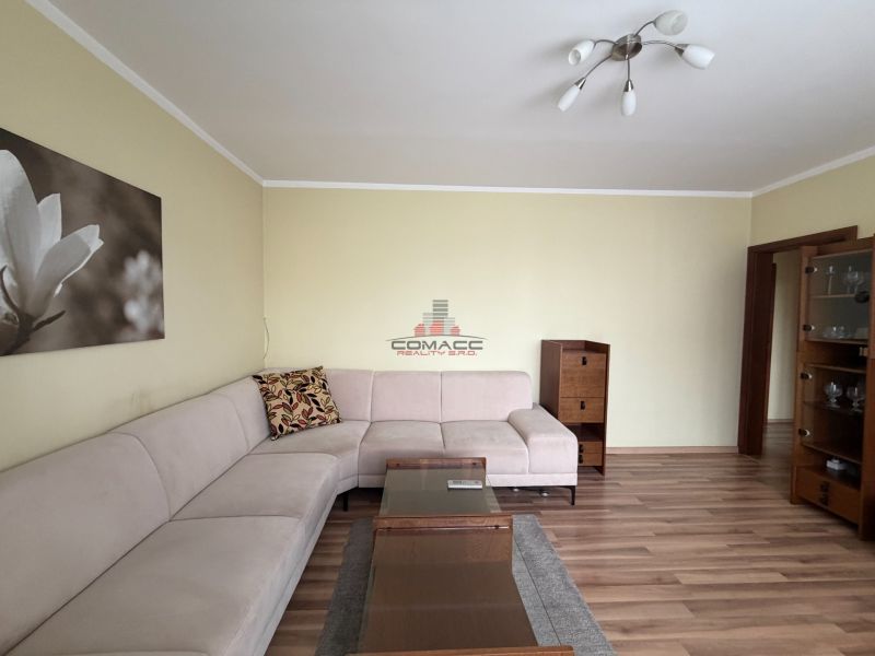 Wohnzimmer in einer 3-Zimmer-Wohnung mit Ecksofa und Holzboden.