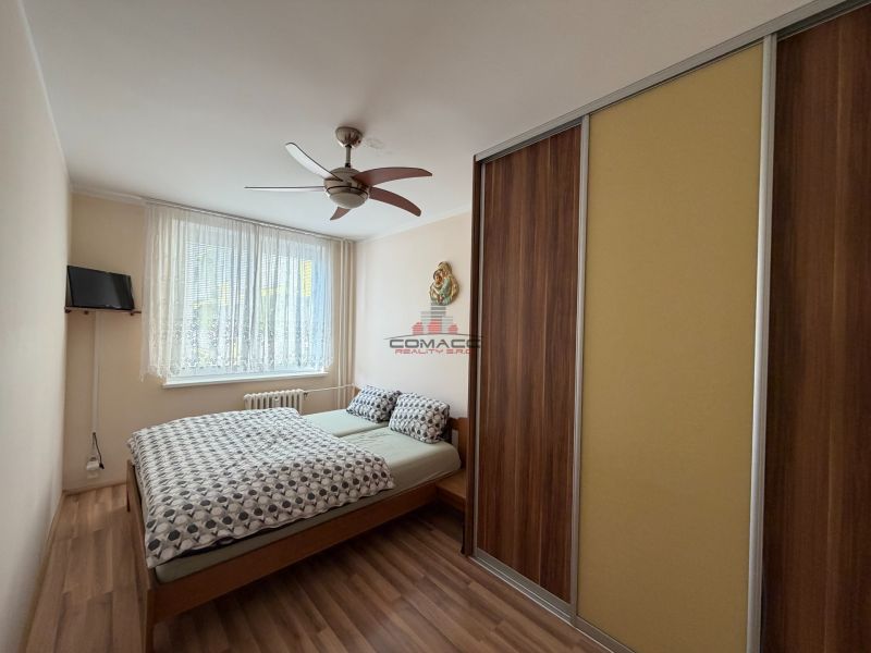 Schlafzimmer in einer 3-Zimmer-Wohnung mit Bett, Schrank und Holzboden.