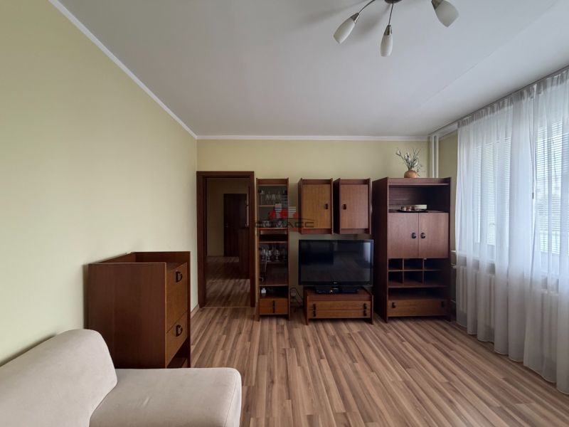 Wohnzimmer in einer 3-Zimmer-Wohnung mit Möbeln und Holzboden.