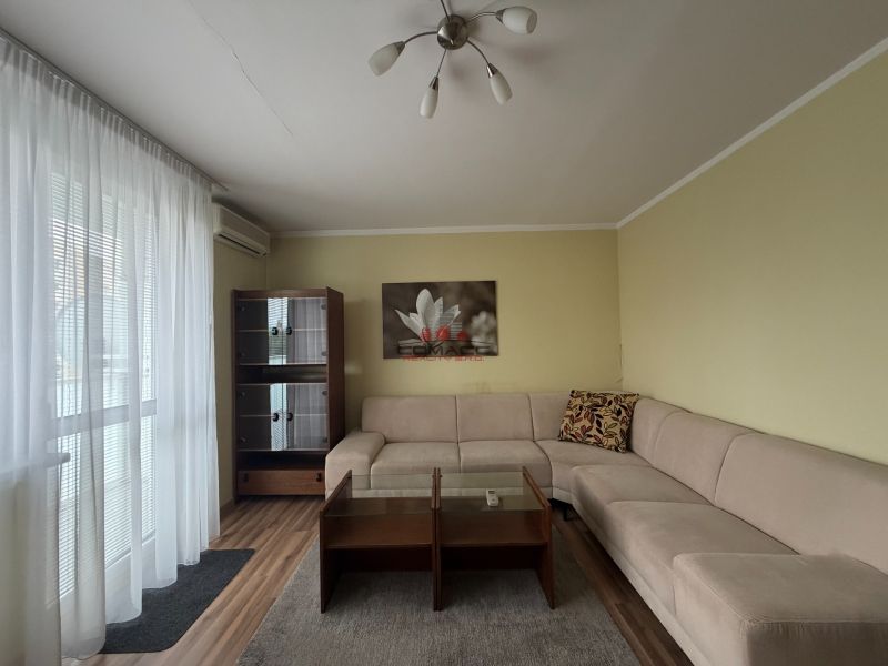 Wohnzimmer in einer 3-Zimmer-Wohnung mit Sofa, Holzboden und Kleiderschrank.