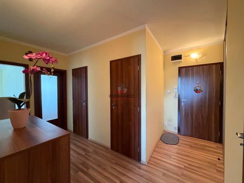 Der Flur in einer 3-Zimmer-Wohnung mit Türen und einem Boden in Holzdekor.