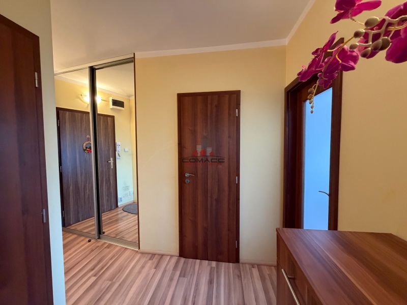 Der Flur in der 3-Zimmer-Wohnung mit einem Boden in Holzoptik und einem Einbauschrank.
