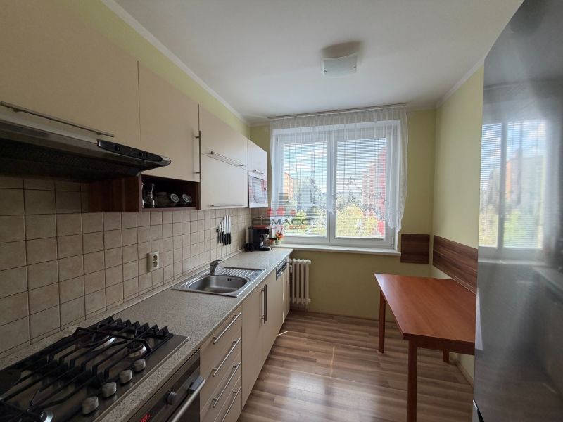 Küche in einer 3-Zimmer-Wohnung mit Holzboden und Esstisch.