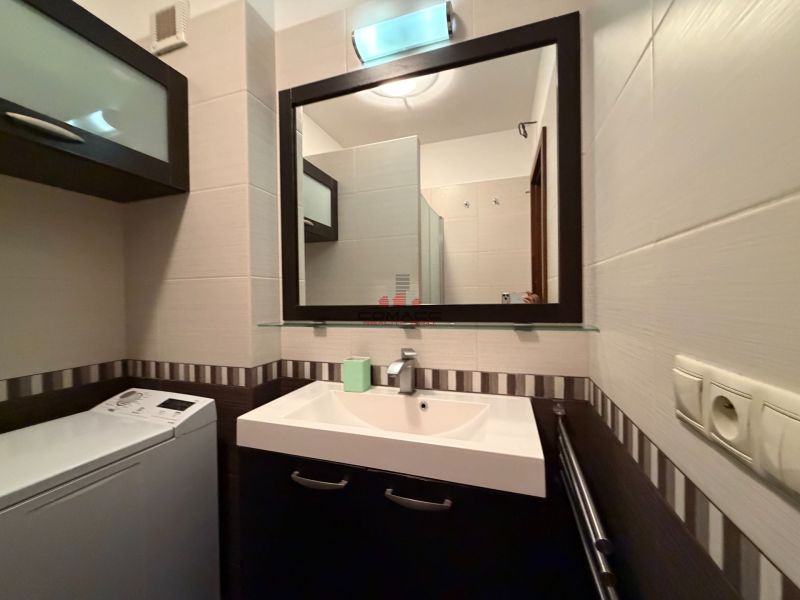 Badezimmer in einer 3-Zimmer-Wohnung mit Waschbecken, Waschmaschine und Spiegel an der Wand.
