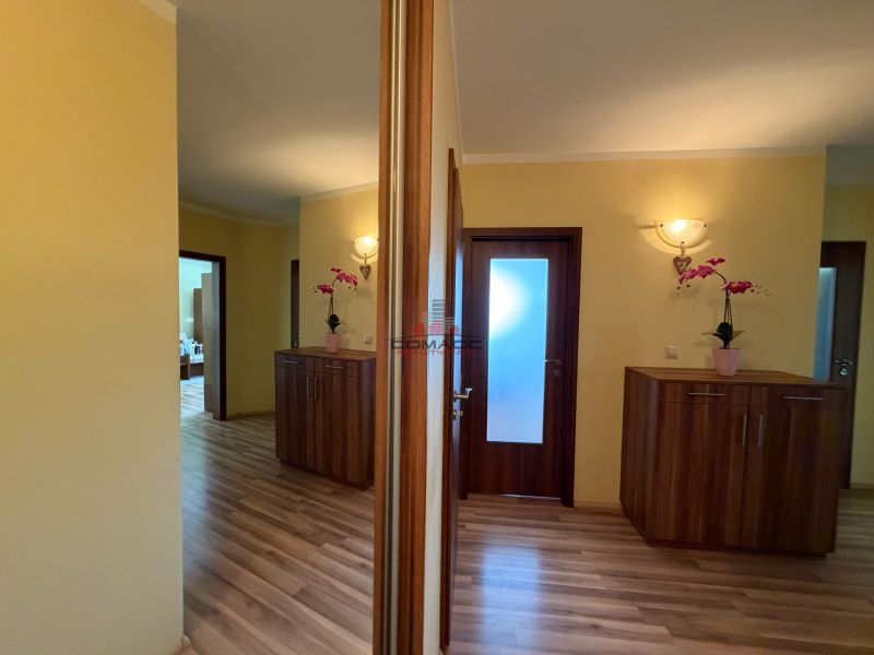 Der Flur in einer 3-Zimmer-Wohnung mit Holzboden und Einbauschränken.