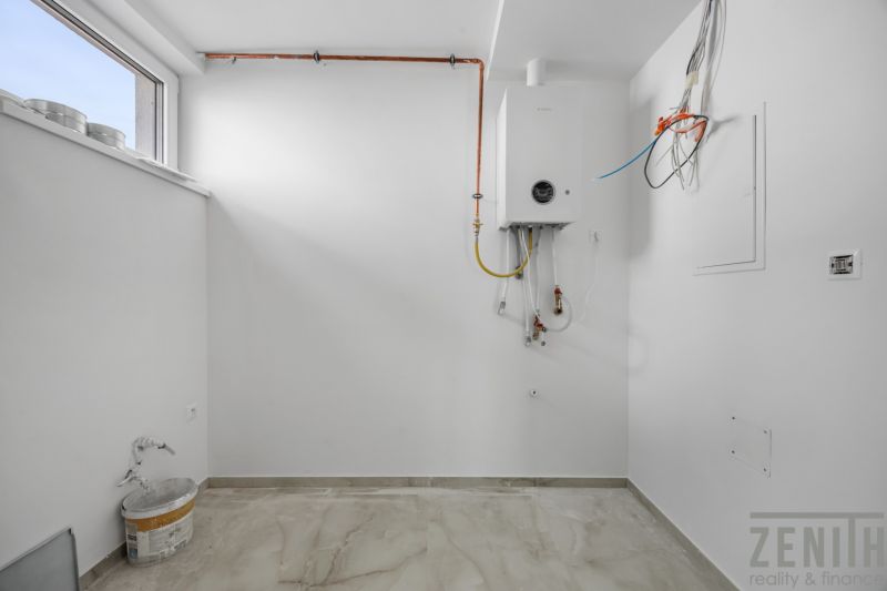 Weißer Raum mit Boiler und Holzboden in einem Einfamilienhaus.