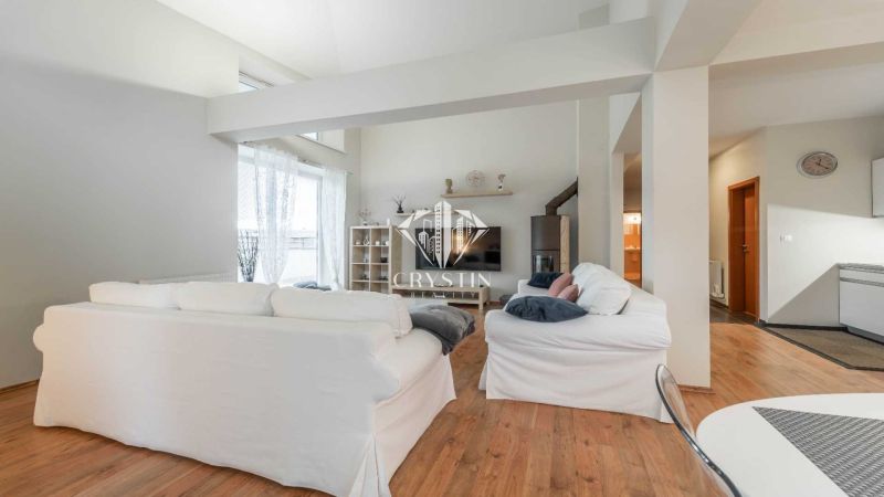 Ferienwohnung mit weißen Sofas und Holzboden, helle Umgebung.