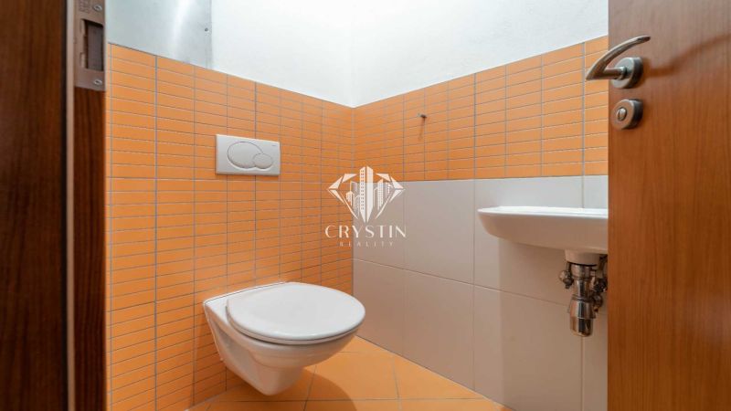 Badezimmer in einer Ferienwohnung mit orangefarbenen Fliesen und Hänge-WC.