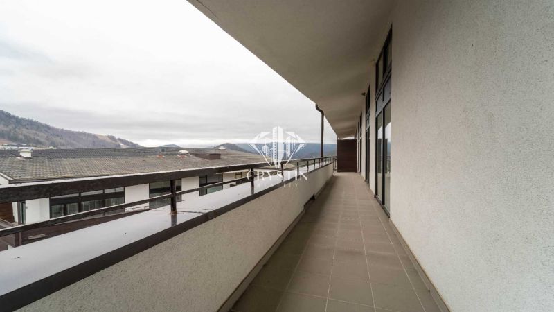 Der Balkon des Ferienapartments in Donovaly bietet Blick auf die umliegenden Berge und die Dächer der Gebäude.
