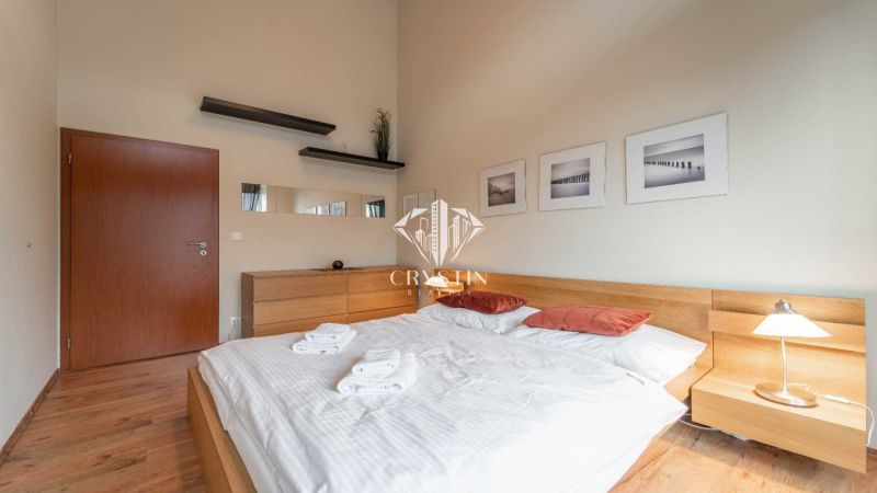 Helles Schlafzimmer in einer Ferienwohnung mit Holzboden und einfacher Einrichtung.