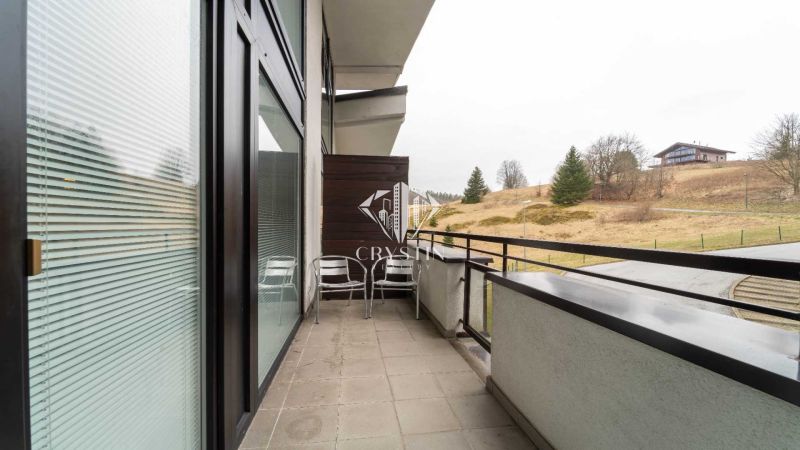 Der Balkon der Ferienwohnung in Donovaly mit Blick auf die Natur und die Hütten.