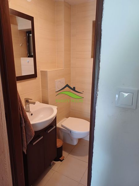 Badezimmer in der Hütte mit Waschbecken, Toilette und hellen Fliesen.