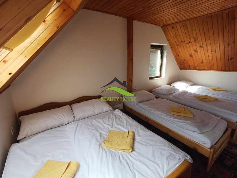Dachzimmer in der Hütte mit fünf Betten und Holzdach.