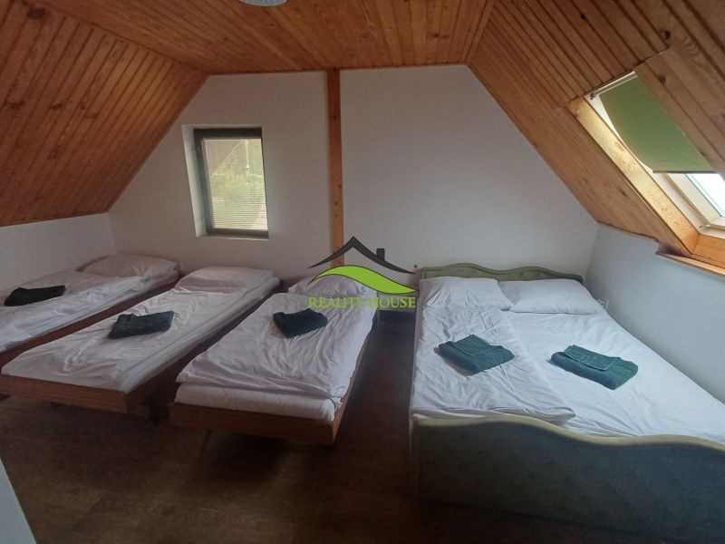 Ein Schlafzimmer in einer Hütte mit drei Betten und einem Boden in Holzoptik.