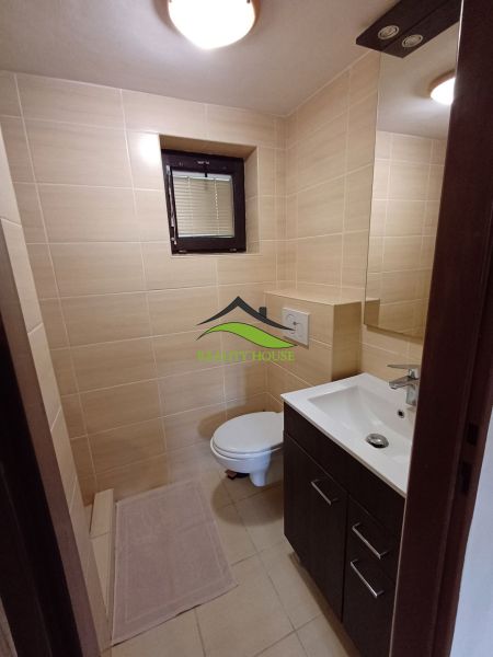 Badezimmer mit hellen Fliesen, Waschbecken und Toilette in der Hütte.