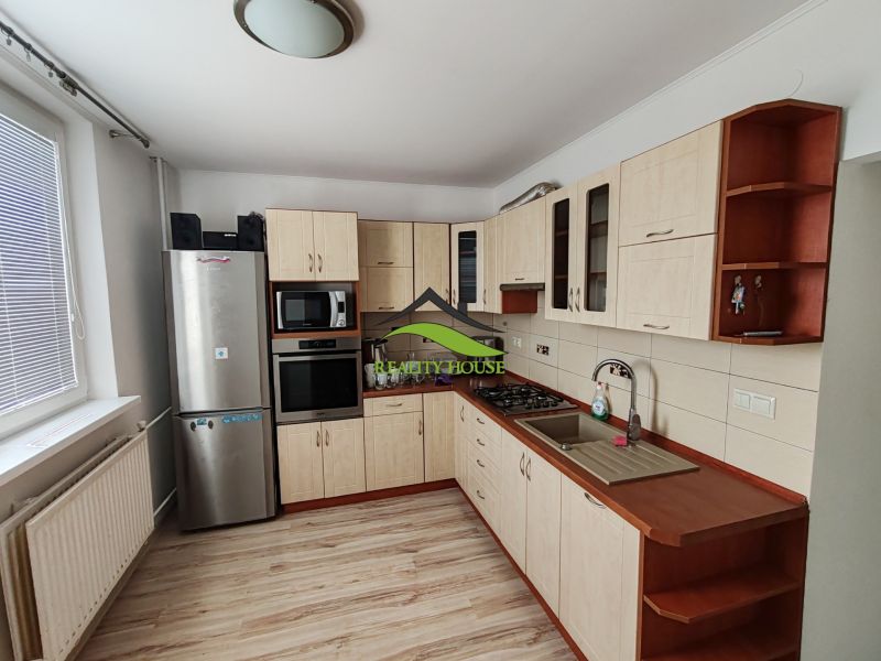 Küche in einer 3-Zimmer-Wohnung mit Holzboden und Geräten.