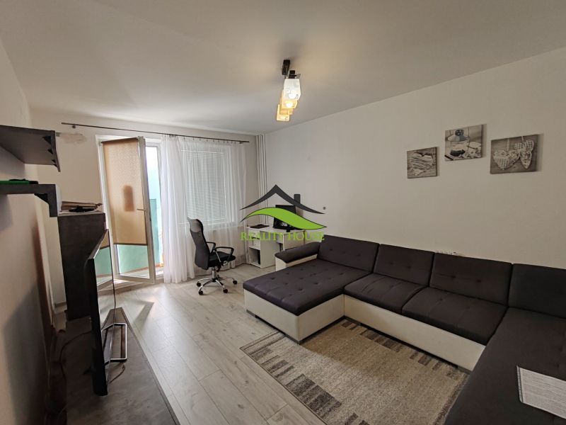 Wohnzimmer in einer 3-Zimmer-Wohnung mit Holzboden, Arbeitsbereich und Sofa.