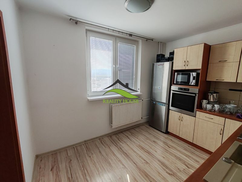 Küche in einer 3-Zimmer-Wohnung mit Fenster und Boden in Holzoptik.