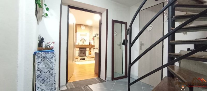 Innenraum eines Einfamilienhauses mit Treppe, Holzboden und Kamin.