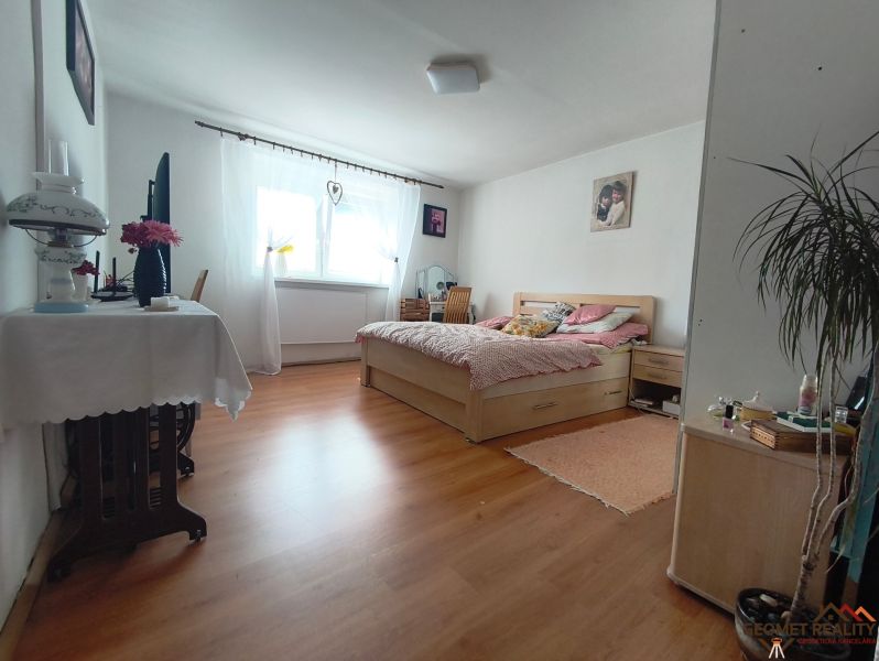 Schlafzimmer im Einfamilienhaus mit Bett und Boden in Holzoptik.