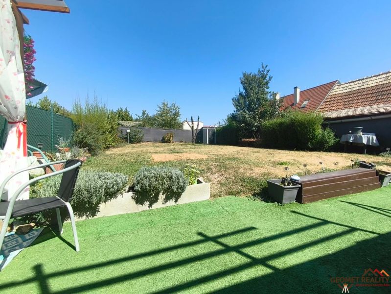 Der Garten des Einfamilienhauses in Divín mit Rasen und einer Terrasse zum Sitzen.