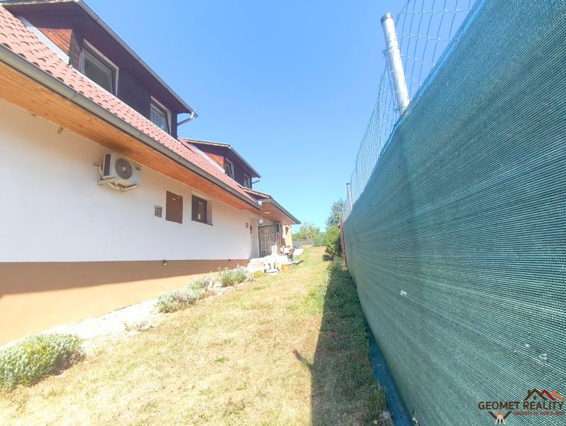 Ein Einfamilienhaus in Divín mit Klimaanlage, Umzäunung und Garten mit Rasen.