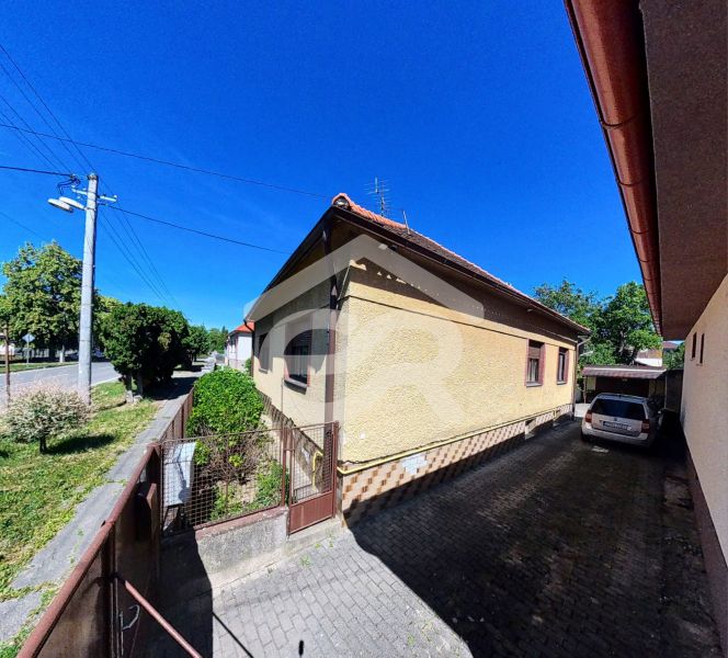Einfamilienhaus in der Sladkovičova 135, Zlaté Moravce, mit einem Auto im Hof und einem Garten.