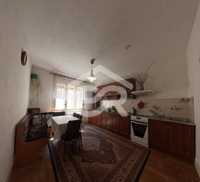 Küche mit Einbauschränken, Gasherd und Holzboden in einem Einfamilienhaus.
