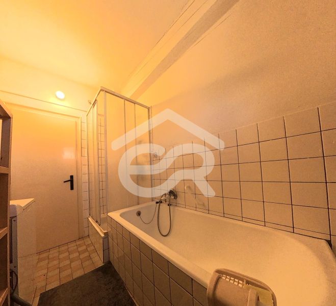 Badezimmer mit Badewanne, Dusche und Fliesen in einem Einfamilienhaus.