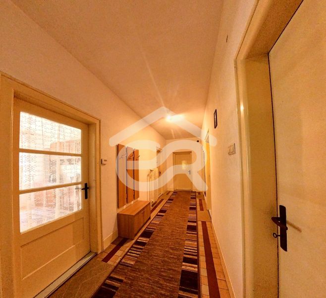 Ein Flur in einem Einfamilienhaus mit langem Boden und Türen mit Glaseinsätzen.