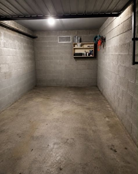 Leere Garage mit einem Werkzeugregal und Beleuchtung, Betonboden.