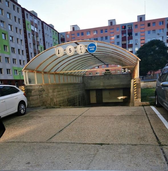 Garagen auf der Rajecká-Straße in Bratislava - Vrakuňa vor Wohnhäusern mit Autos.