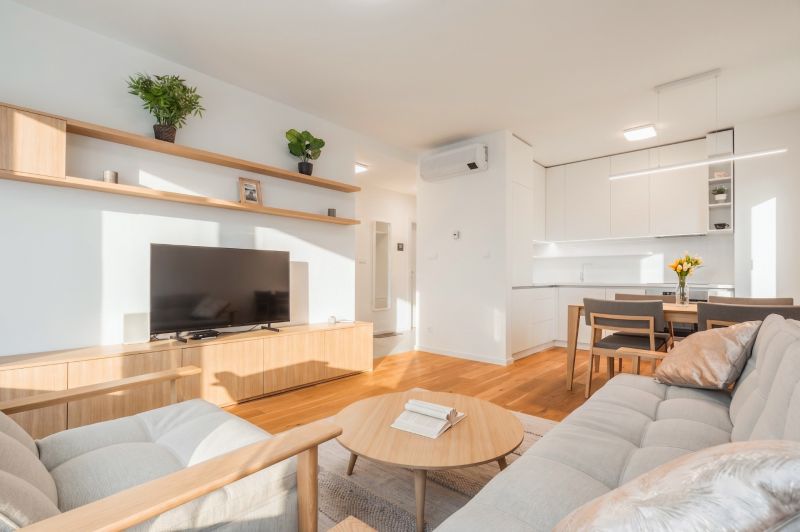 Wohnzimmer in einer 2-Zimmer-Wohnung mit Holzboden und hellen Möbeln.