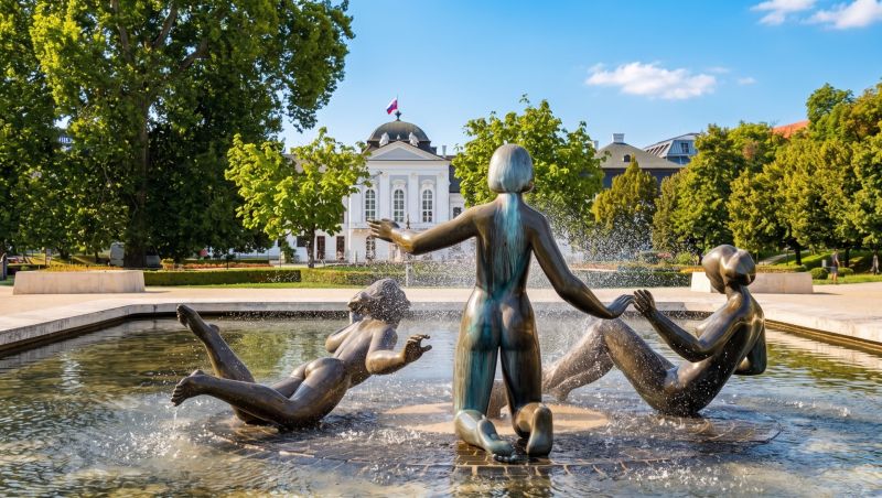 Ein Brunnen mit Bronzeskulpturen und die Präsidentin in den Gärten in Bratislava – Altstadt auf der Banskobystrická.