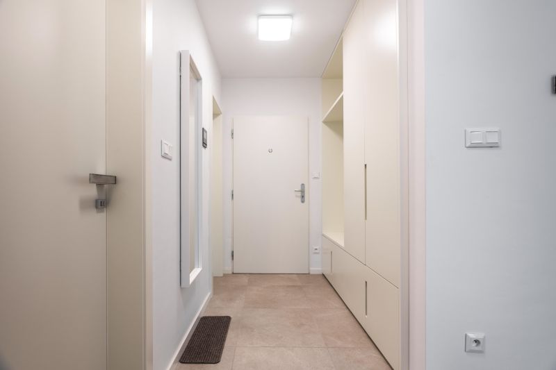 Eingangsflur in einer 2-Zimmer-Wohnung mit Fliesen und Einbauschränken.